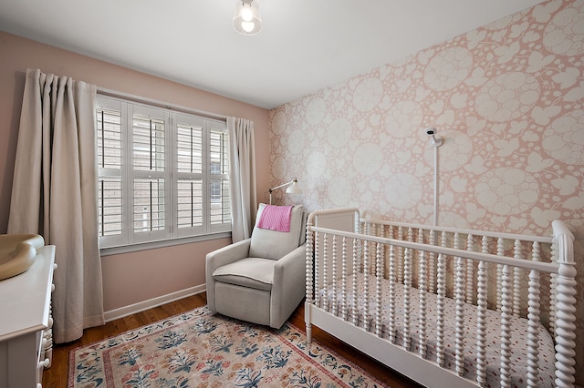bedroom with wallpapered walls, wood finished floors, and baseboards