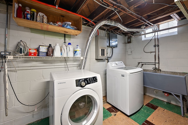 laundry room featuring washing machine and dryer, electric panel, and light floors