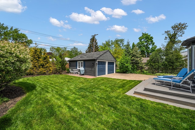 view of grassy yard featuring an outdoor structure, a garage, and a patio area