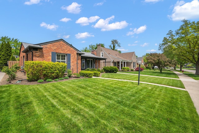 view of front of property with brick siding and a front lawn