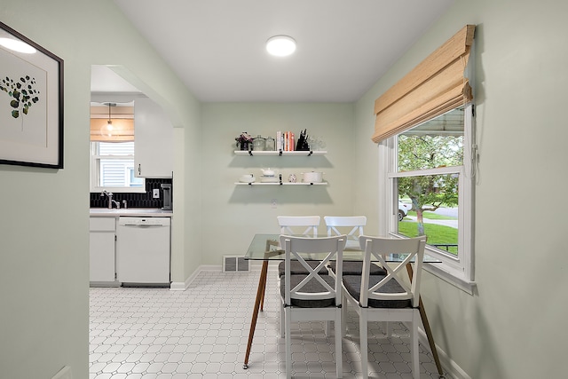 dining area with baseboards and arched walkways