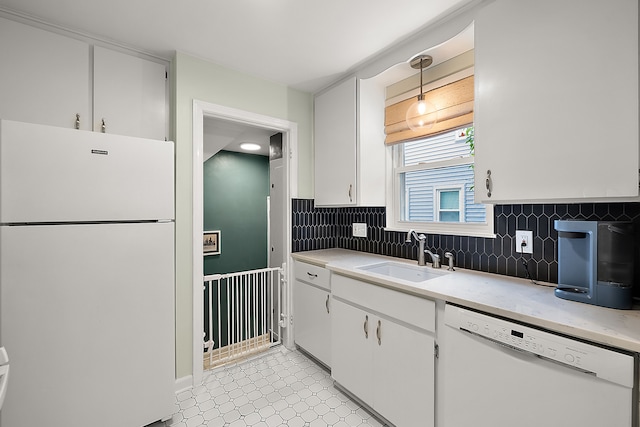 kitchen featuring white appliances, a sink, light countertops, decorative backsplash, and white cabinetry