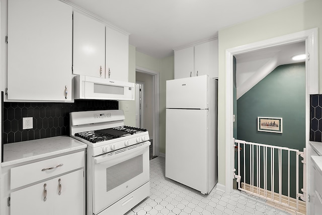 kitchen with white appliances, white cabinetry, and backsplash