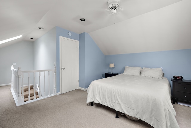 bedroom featuring vaulted ceiling, carpet, baseboards, and a skylight