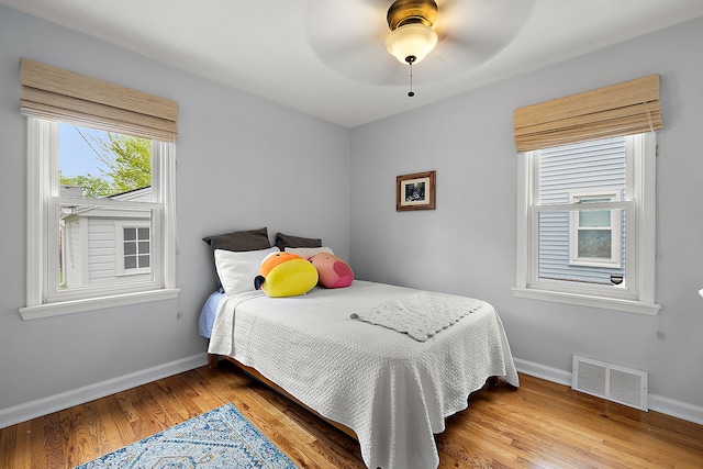 bedroom with baseboards, wood finished floors, and a ceiling fan