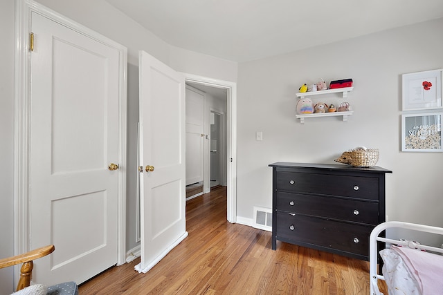 bedroom with light wood-type flooring and baseboards
