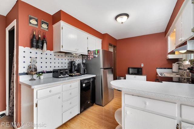94 Crescent Lake Rd, Waterford, MI 48327 - kitchen with black appliances, under cabinet range hood, a sink, white cabinets, and light countertops