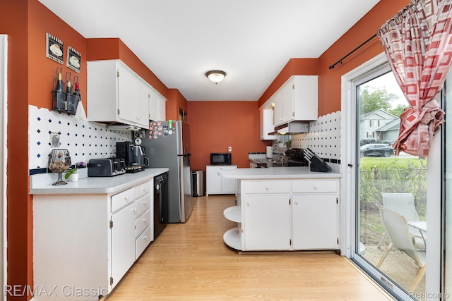 94 Crescent Lake Rd, Waterford, MI 48327 - kitchen with white cabinets, black appliances, light wood finished floors, light countertops, and decorative backsplash