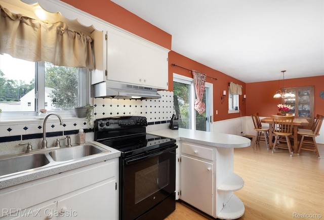 94 Crescent Lake Rd, Waterford, MI 48327 - kitchen featuring black range with electric cooktop, under cabinet range hood, a sink, light countertops, and a peninsula