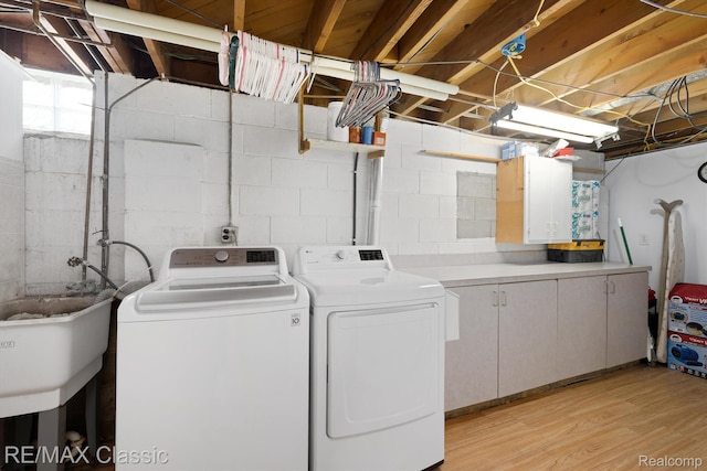 94 Crescent Lake Rd, Waterford, MI 48327 - laundry room with washer and dryer, light wood-style flooring, and cabinet space