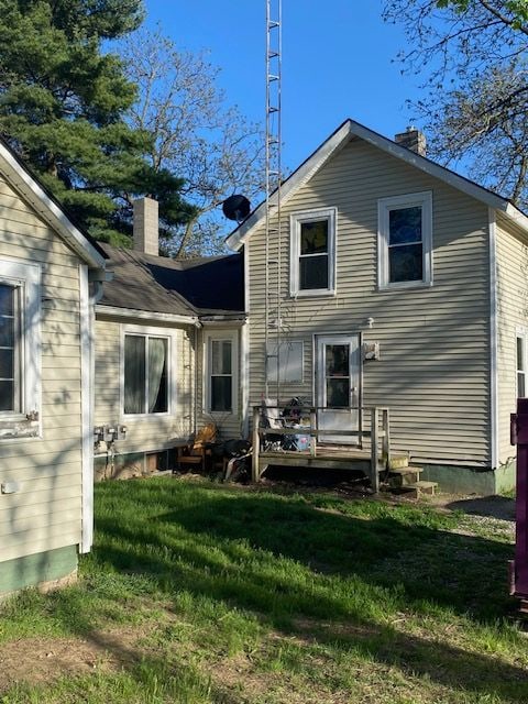 437 W Mount Morris St, Mount Morris, MI 48458 - back of house featuring a chimney and a lawn