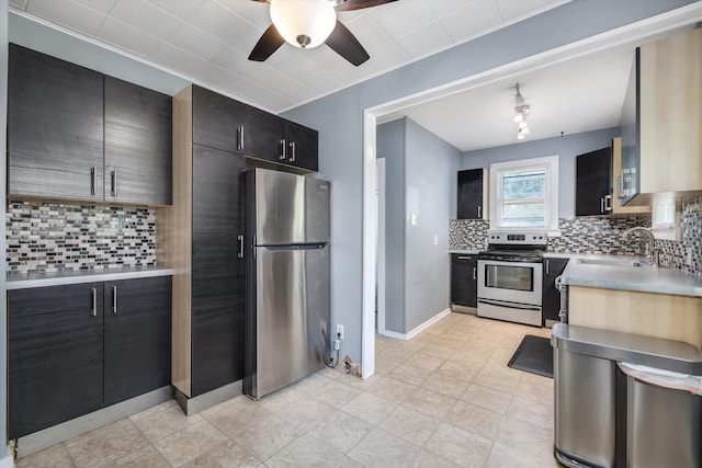 kitchen featuring appliances with stainless steel finishes, a ceiling fan, light countertops, and backsplash