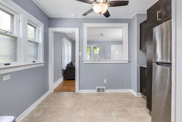 unfurnished dining area with baseboards, a ceiling fan, and ornamental molding