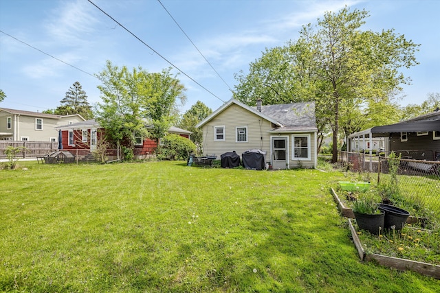 back of property with a vegetable garden and a chimney