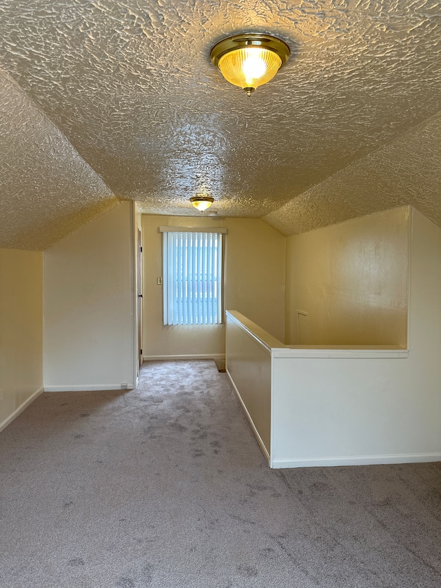 bonus room with a textured ceiling, carpet flooring, vaulted ceiling, and baseboards