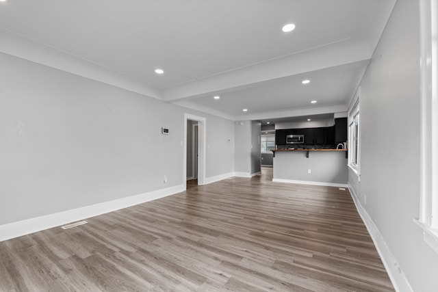 unfurnished living room with recessed lighting, light wood-style floors, baseboards, and healthy amount of natural light