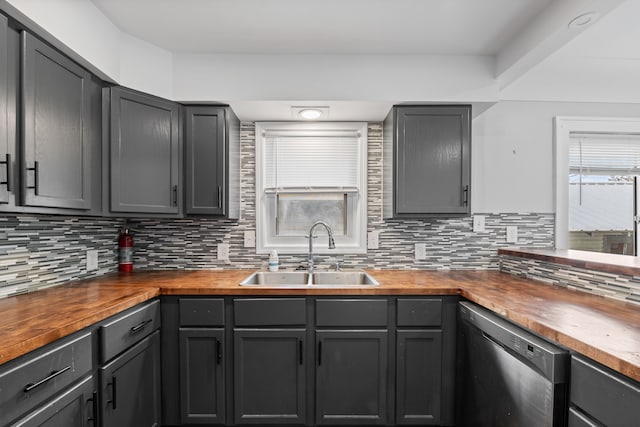 kitchen featuring wood counters, a sink, dishwasher, tasteful backsplash, and gray cabinetry