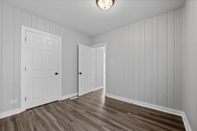 unfurnished bedroom with dark wood-style floors and baseboards