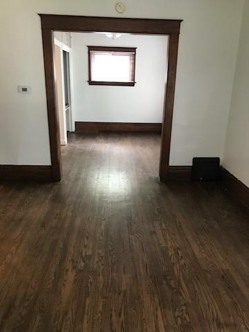 spare room with dark wood finished floors and baseboards
