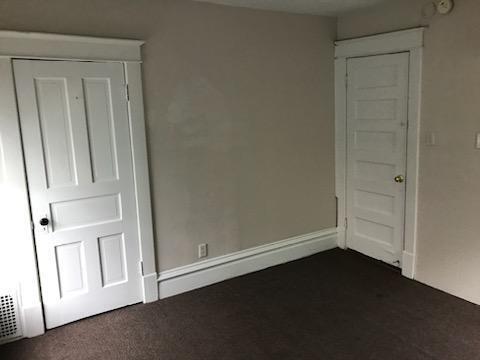 unfurnished bedroom featuring dark colored carpet