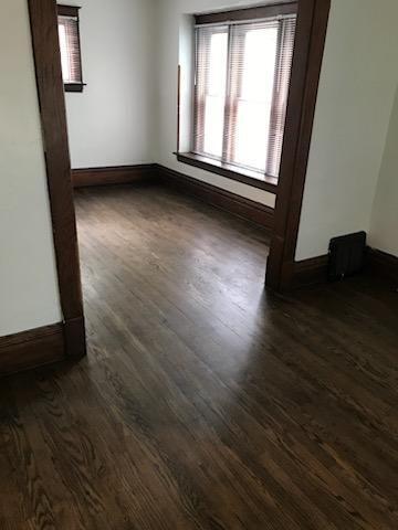 empty room featuring dark wood finished floors, healthy amount of natural light, and baseboards