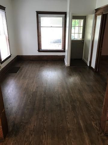 unfurnished room with dark wood-type flooring and baseboards