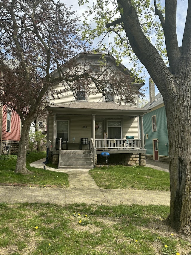 view of front of home featuring covered porch and a front lawn