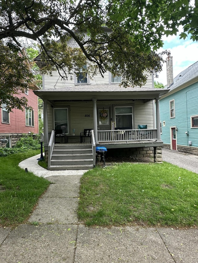 view of front of home featuring covered porch and a front yard