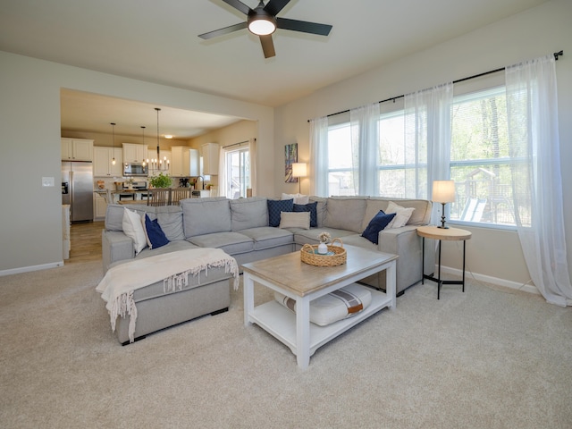 59376 Silvergrass Ave, Mattawan, MI 49071 - living room with a ceiling fan, baseboards, light carpet, and a chandelier