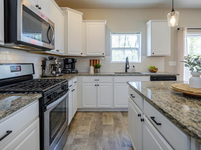 59376 Silvergrass Ave, Mattawan, MI 49071 - kitchen with appliances with stainless steel finishes, a sink, white cabinetry, and tasteful backsplash