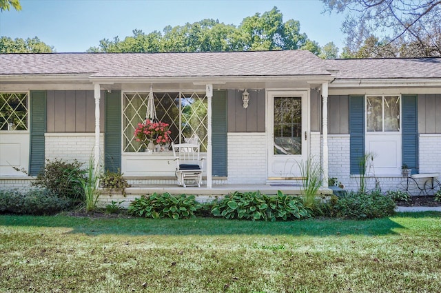 10186 Carlee June Dr, Fenton, MI 48430 - property entrance featuring brick siding, a yard, and a shingled roof