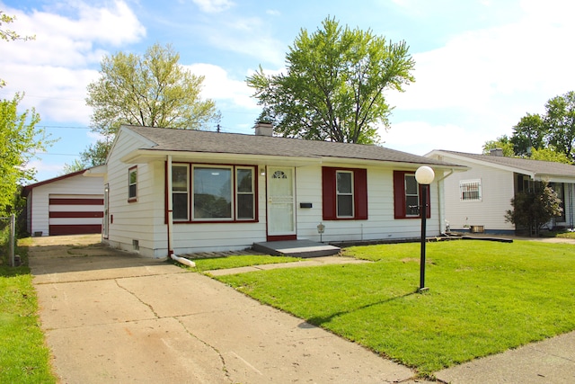view of front of house with a front lawn, a chimney, an outbuilding, and a garage
