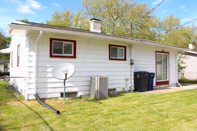 back of property with central air condition unit and a chimney
