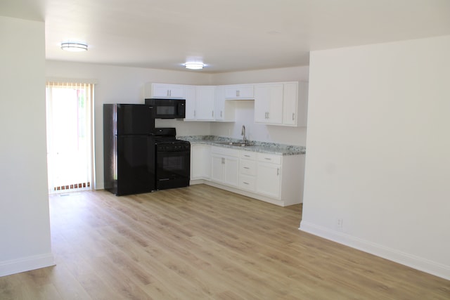 kitchen featuring black appliances, baseboards, white cabinets, light wood-type flooring, and light stone counters