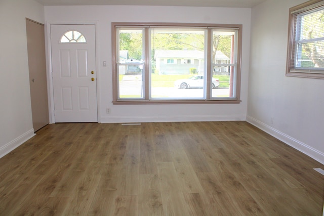 foyer entrance with wood finished floors and baseboards