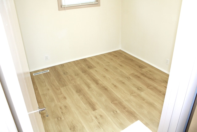 spare room with wood finished floors and baseboards