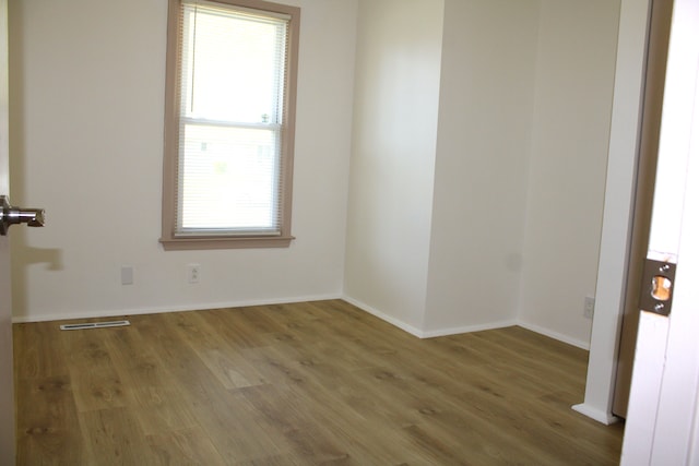 spare room featuring wood finished floors and baseboards
