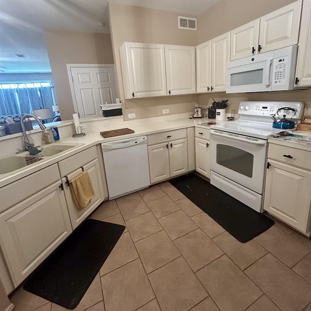 kitchen with white appliances, a sink, and white cabinets