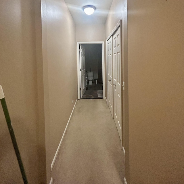 hall with baseboards and carpet flooring