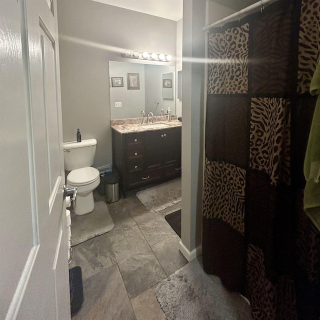 bathroom with tiled shower, toilet, and vanity