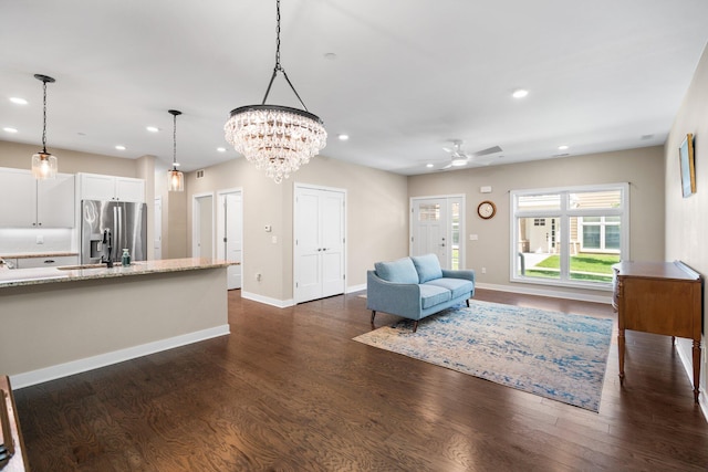 611 Woodland Dr, Dexter, MI 48130 - living room with dark wood-style floors, recessed lighting, ceiling fan, baseboards, and a chandelier