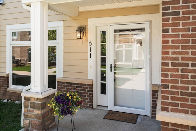 611 Woodland Dr, Dexter, MI 48130 - view of exterior entry with a porch and brick siding