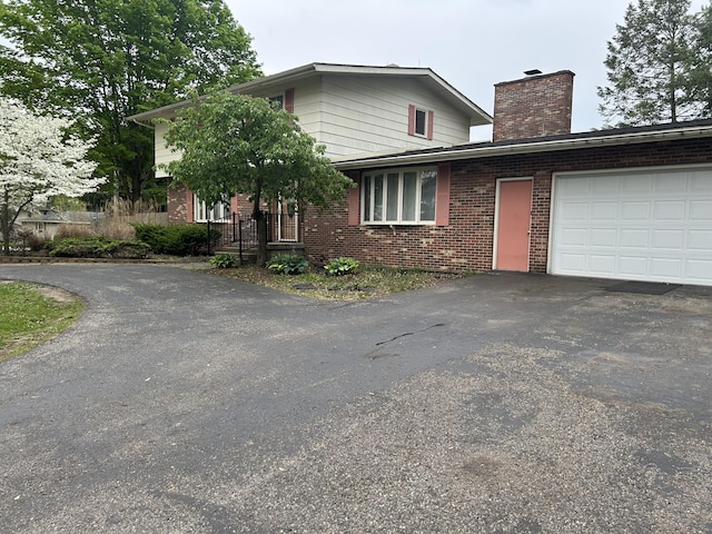 29 Douglas Ave, Coldwater, MI 49036 - view of front of home featuring driveway, brick siding, a garage, and a chimney
