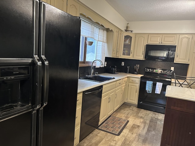 29 Douglas Ave, Coldwater, MI 49036 - kitchen featuring black appliances, a sink, light countertops, light wood finished floors, and decorative backsplash