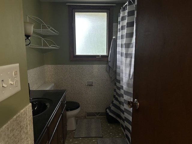 29 Douglas Ave, Coldwater, MI 49036 - bathroom with tile walls, toilet, vanity, wainscoting, and tile patterned flooring