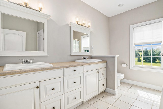 7812 Fountain Hills Ln, Davisburg, MI 48350 - bathroom featuring toilet, double vanity, baseboards, and tile patterned floors