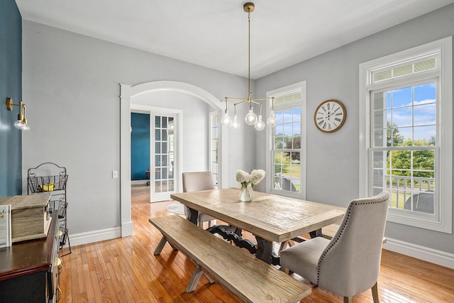 7812 Fountain Hills Ln, Davisburg, MI 48350 - dining space featuring baseboards, arched walkways, and light wood finished floors