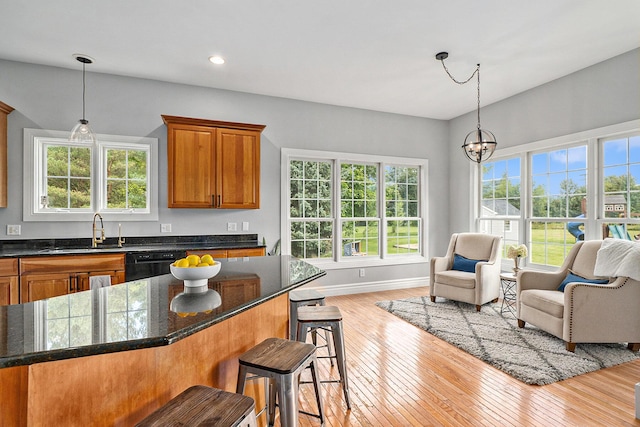 7812 Fountain Hills Ln, Davisburg, MI 48350 - kitchen with a sink, dishwasher, light wood finished floors, brown cabinetry, and a breakfast bar area