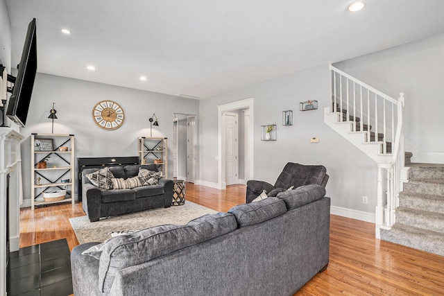 7812 Fountain Hills Ln, Davisburg, MI 48350 - living area featuring stairs, light wood-style flooring, recessed lighting, baseboards, and a fireplace with flush hearth