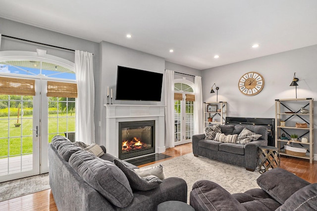 7812 Fountain Hills Ln, Davisburg, MI 48350 - living room featuring a fireplace with flush hearth, wood finished floors, recessed lighting, and french doors